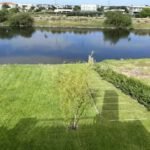 Jardín con conexión directa al lago en Casa La Toscana, paisajismo realizado por Fusión Nativa en Zona Norte.