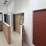 Vista interior del local comercial con ventana de atención y revestimientos de madera en proceso de obra